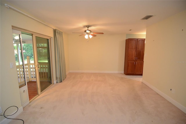 empty room featuring ceiling fan and light colored carpet