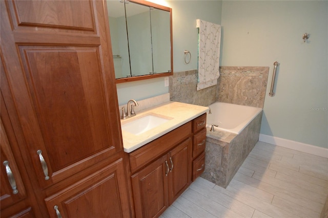 bathroom with vanity and tiled tub