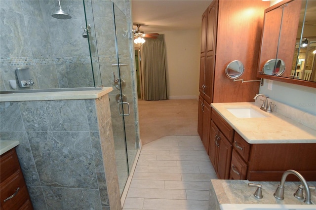 bathroom with ceiling fan, a shower with door, and vanity