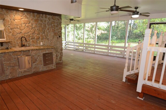 wooden terrace featuring ceiling fan and sink