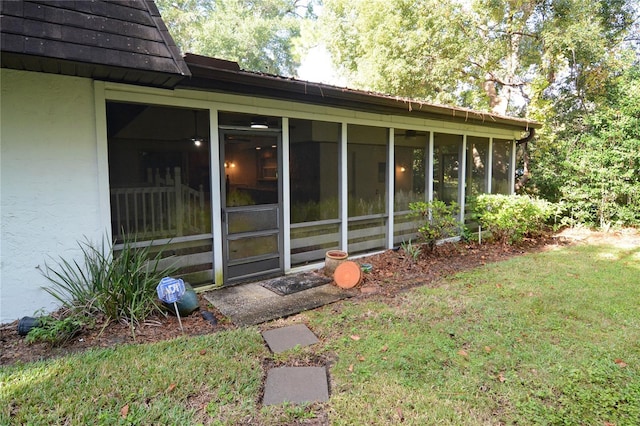 view of side of home featuring a yard and a sunroom