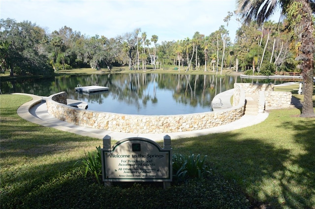 surrounding community with a water view and a yard