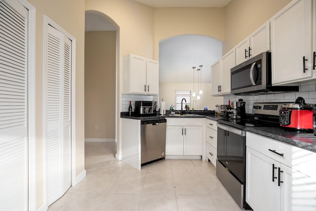 kitchen featuring white cabinets, pendant lighting, and stainless steel appliances