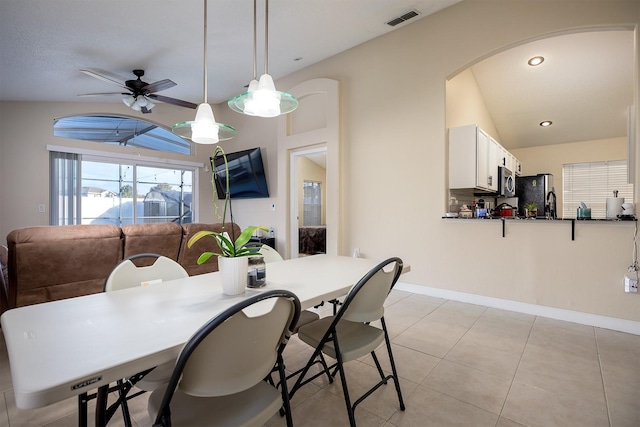 tiled dining space featuring vaulted ceiling and ceiling fan