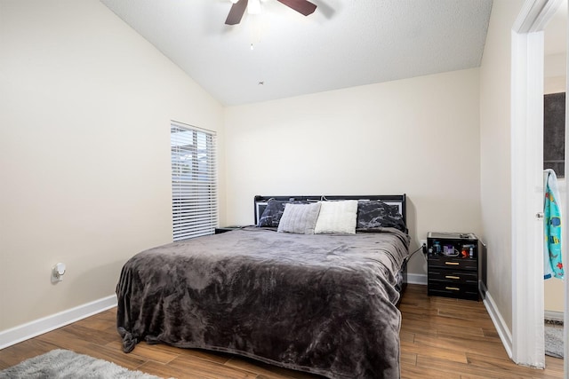 bedroom with ceiling fan, wood-type flooring, and vaulted ceiling