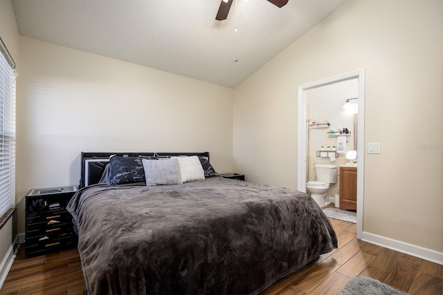 bedroom featuring dark wood-type flooring, vaulted ceiling, ceiling fan, a textured ceiling, and connected bathroom