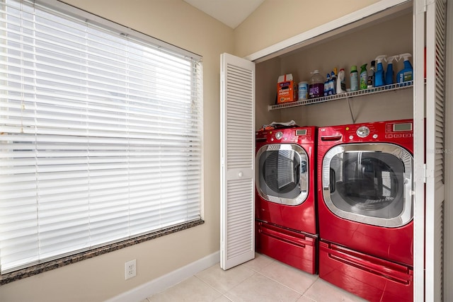 clothes washing area with washer and clothes dryer and light tile patterned floors