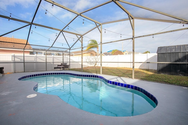 view of pool with glass enclosure and a patio area