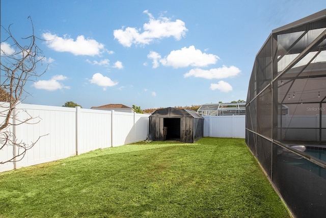 view of yard featuring a shed and glass enclosure