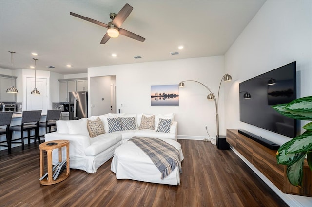 living room with ceiling fan and dark hardwood / wood-style flooring