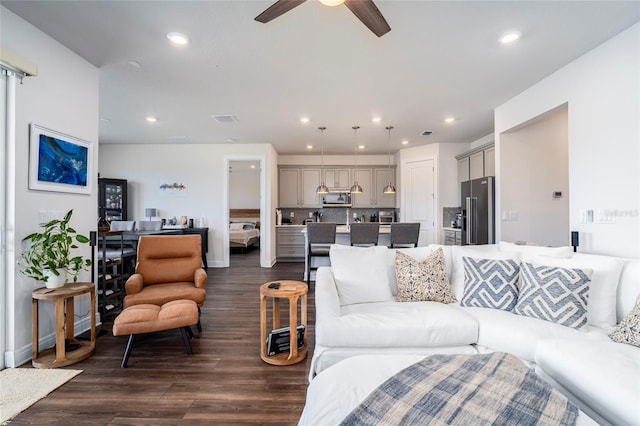 living room featuring ceiling fan and dark wood-type flooring