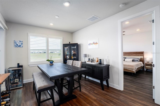 dining space featuring dark hardwood / wood-style floors and a textured ceiling