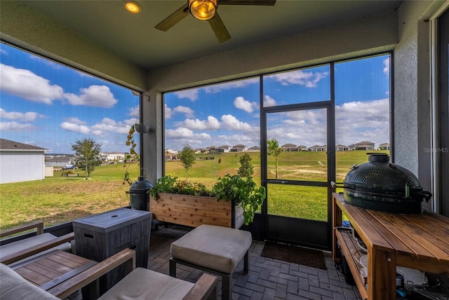 sunroom featuring ceiling fan