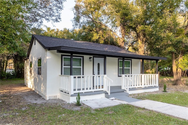 ranch-style home featuring covered porch and a front lawn