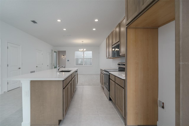 kitchen featuring appliances with stainless steel finishes, a kitchen island with sink, sink, a chandelier, and hanging light fixtures