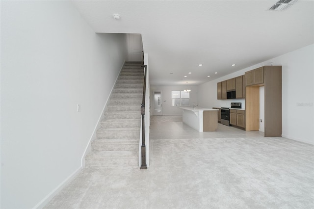 stairs featuring carpet, a chandelier, and sink