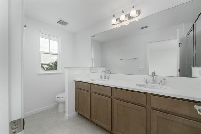 bathroom featuring tile patterned floors, vanity, toilet, and an enclosed shower