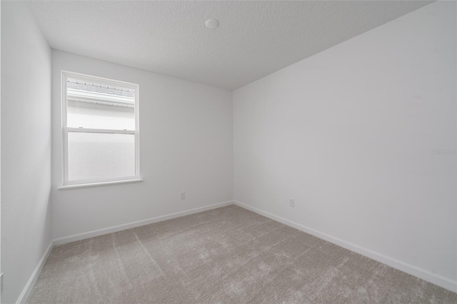 carpeted spare room with a textured ceiling