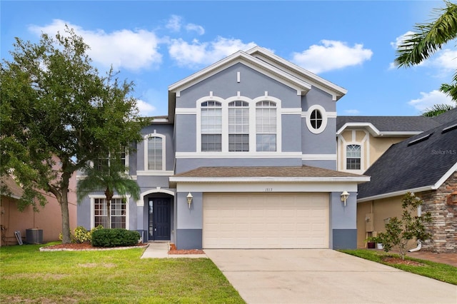 view of front of house featuring central air condition unit, a front yard, and a garage