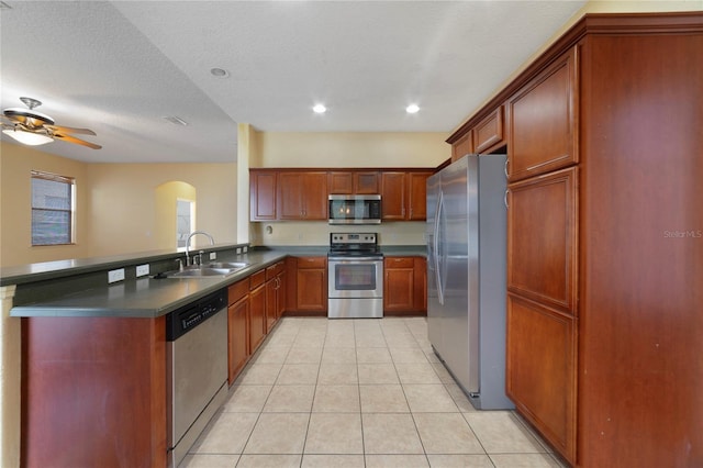 kitchen featuring sink, ceiling fan, light tile patterned floors, a textured ceiling, and appliances with stainless steel finishes