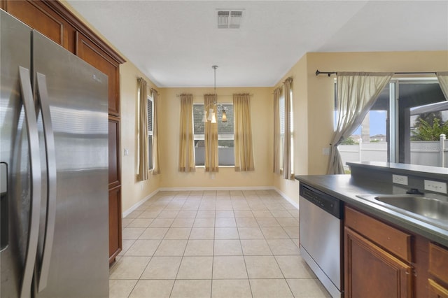 kitchen with sink, light tile patterned floors, decorative light fixtures, stainless steel appliances, and a chandelier