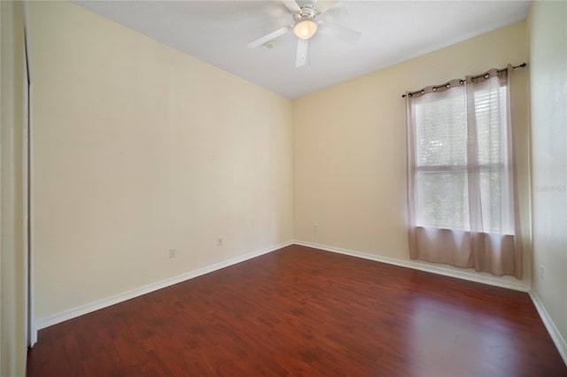 empty room with dark hardwood / wood-style floors and ceiling fan