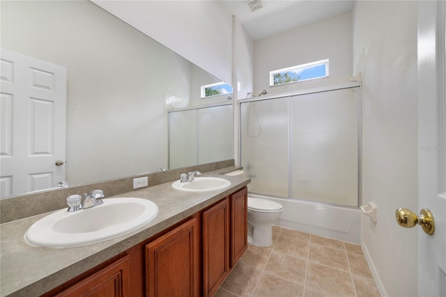 full bathroom featuring tile patterned flooring, vanity, enclosed tub / shower combo, and toilet