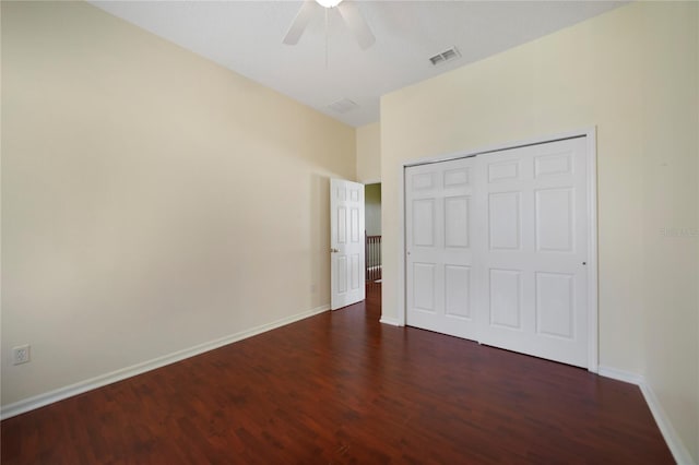 unfurnished bedroom with dark hardwood / wood-style flooring, a closet, and ceiling fan