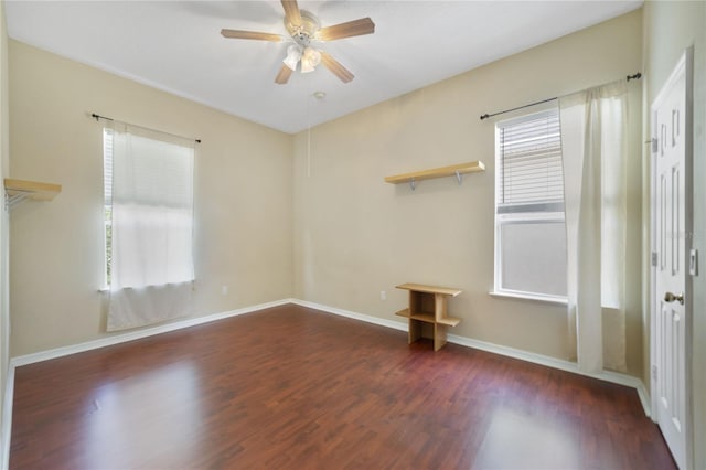 spare room with a wealth of natural light and dark wood-type flooring