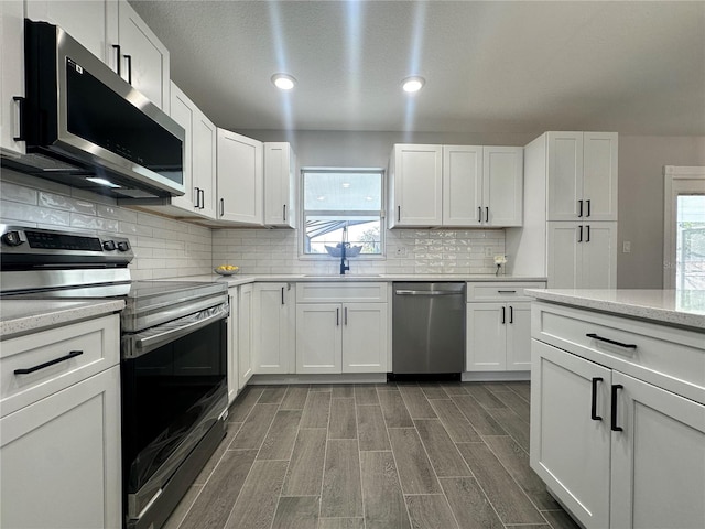 kitchen featuring a wealth of natural light, white cabinets, and appliances with stainless steel finishes