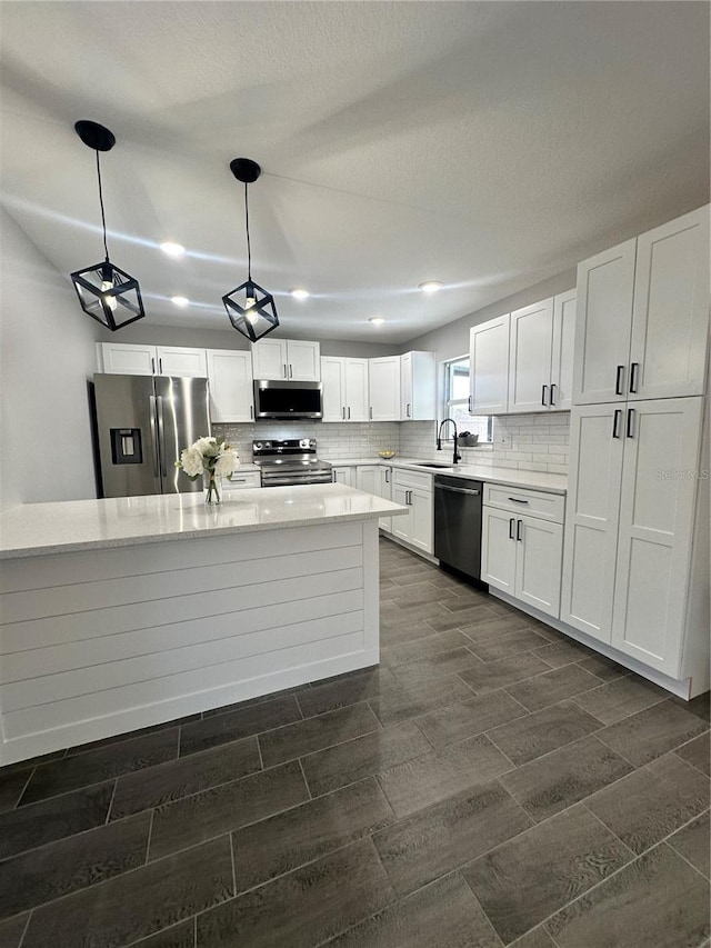 kitchen with stainless steel appliances, white cabinetry, and sink