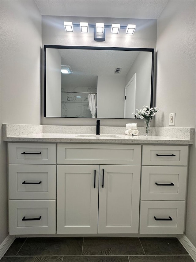 bathroom featuring tile patterned flooring, a shower with curtain, and vanity