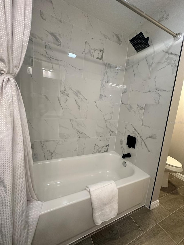 bathroom featuring tile patterned floors, toilet, and shower / bath combo with shower curtain