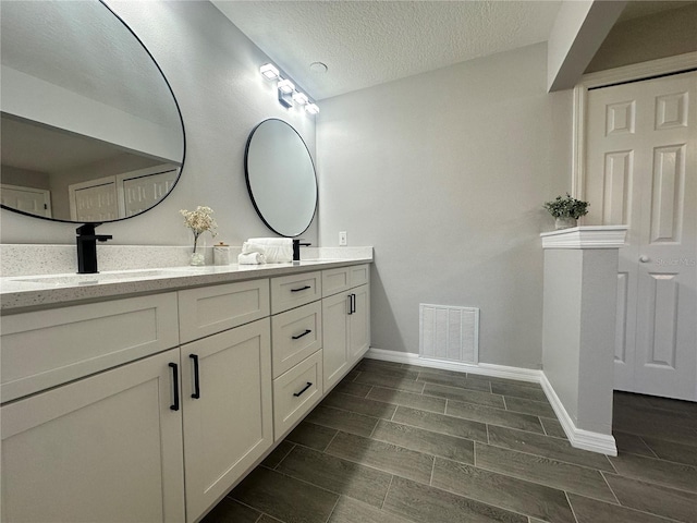 bathroom with vanity and a textured ceiling