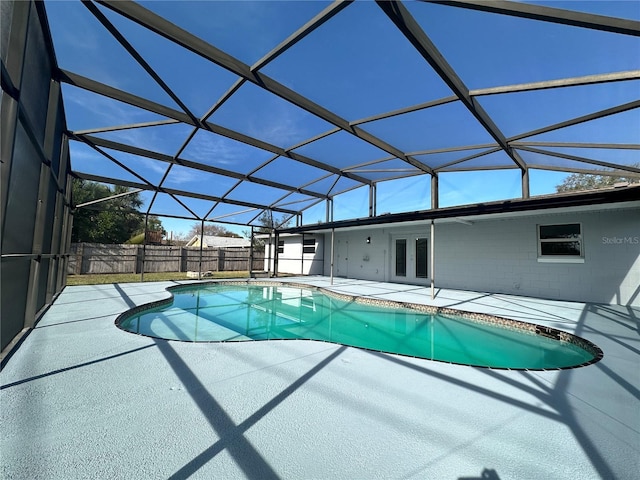 view of pool with glass enclosure, a patio area, and french doors