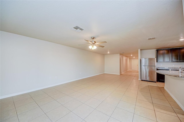 unfurnished living room with ceiling fan and light tile patterned flooring