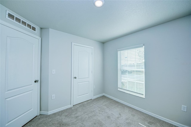 unfurnished bedroom with light colored carpet