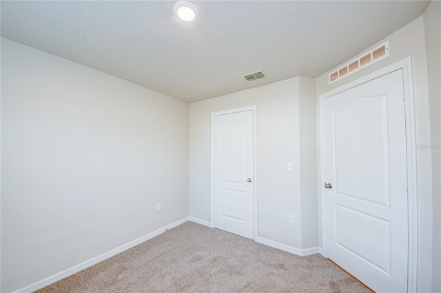 unfurnished bedroom featuring a closet and light colored carpet