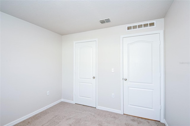 unfurnished bedroom featuring light carpet