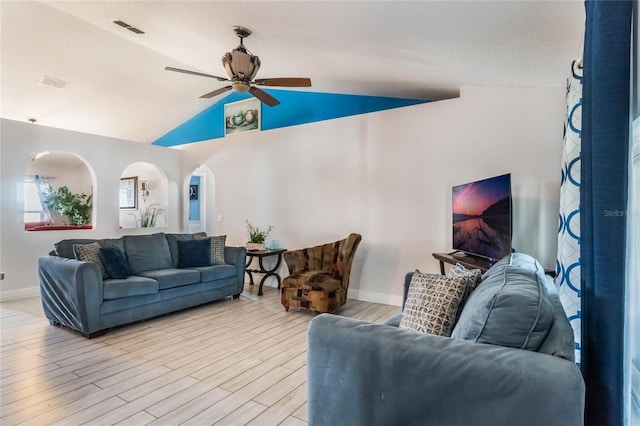 living room featuring a textured ceiling, ceiling fan, light hardwood / wood-style flooring, and vaulted ceiling