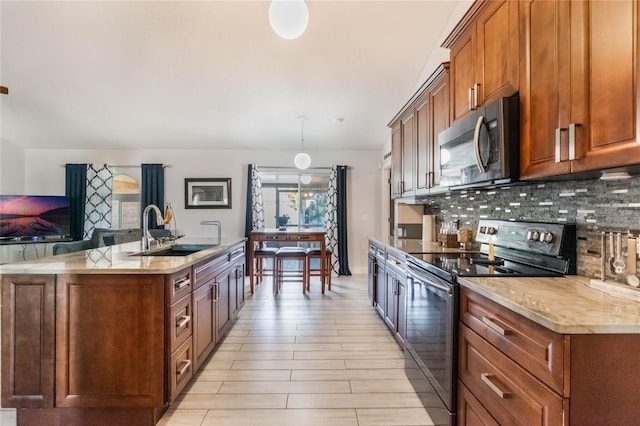 kitchen with tasteful backsplash, sink, electric range, decorative light fixtures, and light hardwood / wood-style flooring