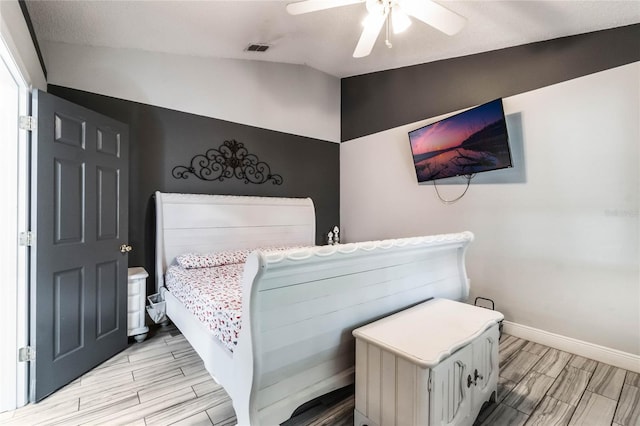 bedroom with light wood-type flooring, vaulted ceiling, and ceiling fan