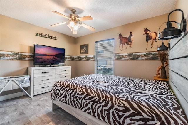 bedroom with light wood-type flooring, a textured ceiling, and ceiling fan