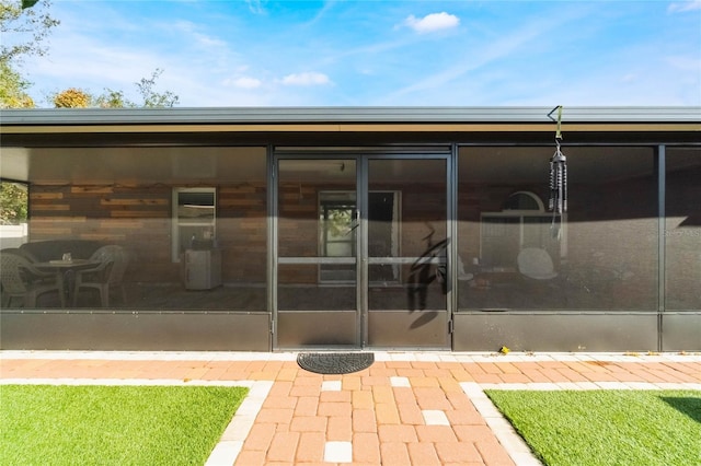 rear view of property featuring a sunroom