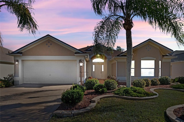 single story home with a garage and a yard