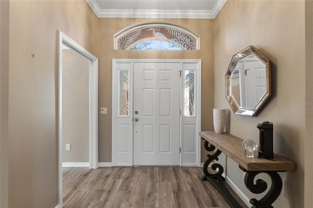 foyer entrance with crown molding and hardwood / wood-style flooring