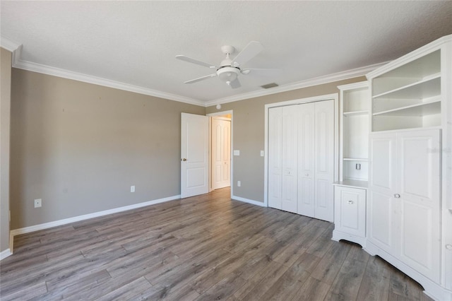 unfurnished bedroom with hardwood / wood-style floors, ceiling fan, and ornamental molding