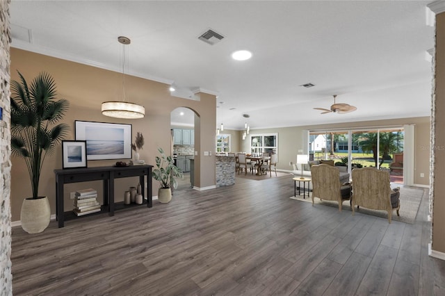 living room featuring ceiling fan, dark hardwood / wood-style flooring, and ornamental molding