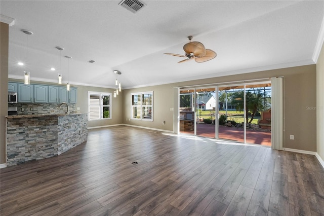 unfurnished living room with ceiling fan, sink, dark wood-type flooring, crown molding, and lofted ceiling