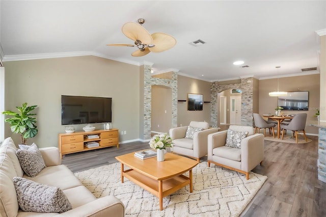 living room with lofted ceiling, hardwood / wood-style flooring, ceiling fan, and crown molding